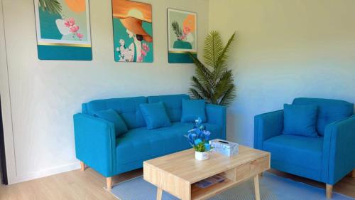 a living room with two blue couches and a coffee table at Ao Nang Escapes Tropical Villas & Studios in Ao Nang Beach