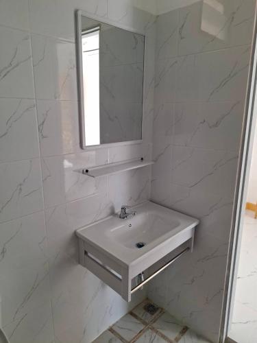 a white bathroom with a sink and a mirror at บีริช รีสอร์ท ขอนแก่น in Khon Kaen