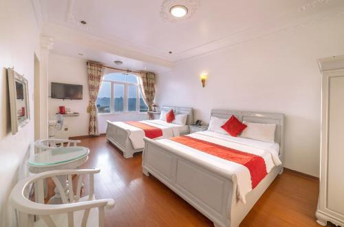 a hotel room with two beds and a table at Dragon King 1 Hotel in Da Lat