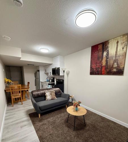 a living room with a couch and a table at Newly Built Cozy Cove Suite in Regina