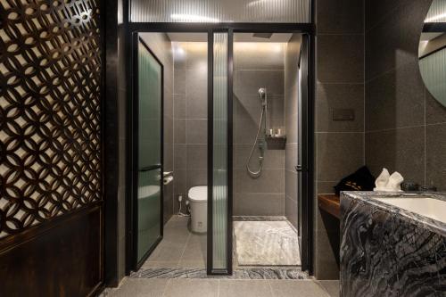 a bathroom with a shower and a toilet and a sink at Floral Hotel Taipingli in Quanjiao