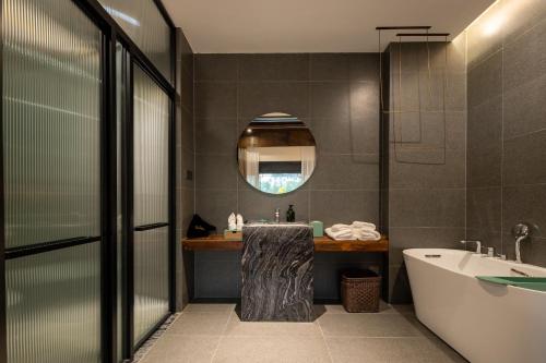 a bathroom with a tub and a sink and a bath tub at Floral Hotel Taipingli in Quanjiao