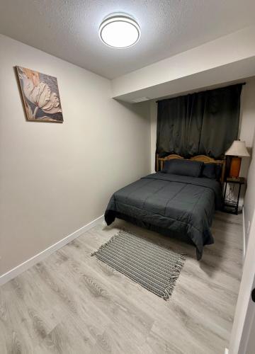 a bedroom with a bed in the corner of a room at Newly Built Cozy Cove Suite in Regina