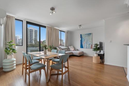 a living room with a table and chairs and a couch at East Perth modern 2 Bedroom with Pool & parking in Perth