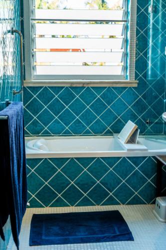 a bathroom with blue tiled walls and a bath tub at Pueblo at Indigal - Relax Rejuvenate Reconnect in Charlotte Bay
