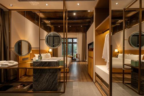 a hotel room with a bathroom with a vanity and mirrors at Floral Hotel Taipingli in Quanjiao