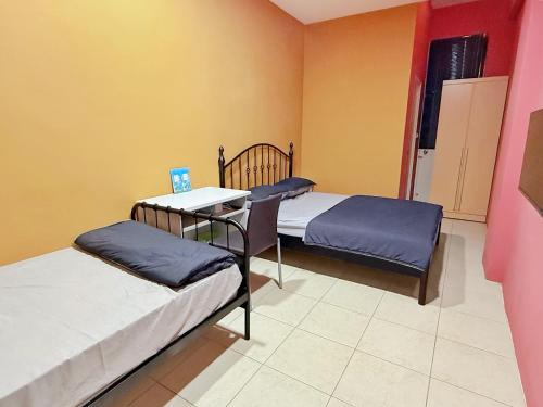 a room with two beds and a table and chairs at Kinmen Wagui B&B in Jinning
