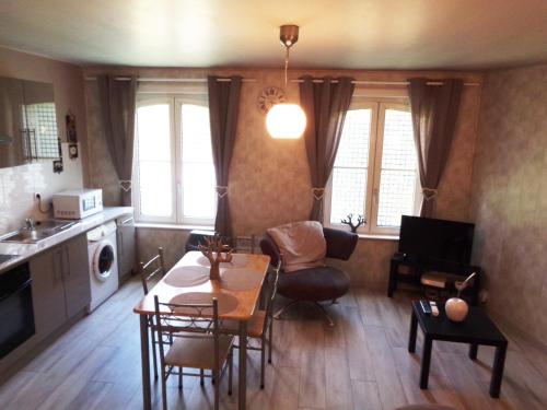 a kitchen and living room with a table and chairs at Les Petits Souliers in Lestrem