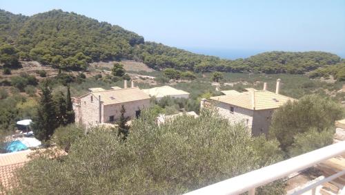 a group of houses on a hill with trees at Revera Traditional Stone Villas, Apartments & Studios in Keri