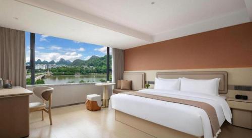 a bedroom with a large bed and a large window at Immersing Hotel Guilin Two Rivers and Four Lakes Dongxi Alley in Guilin