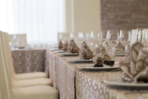 a row of tables with wine glasses and napkins at Hotel L'Aragosta in Casalbordino