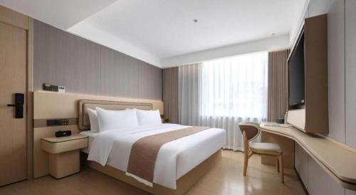 a hotel room with a large bed and a television at Immersing Hotel Guilin Two Rivers and Four Lakes Dongxi Alley in Guilin