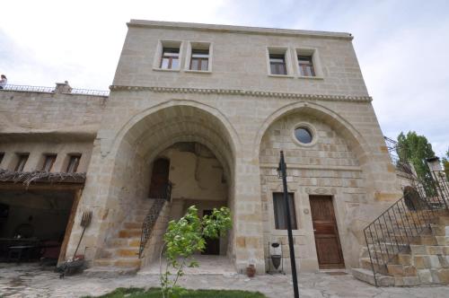 a large stone building with an archway in front at Dreams Cave Hotel in Ortahisar