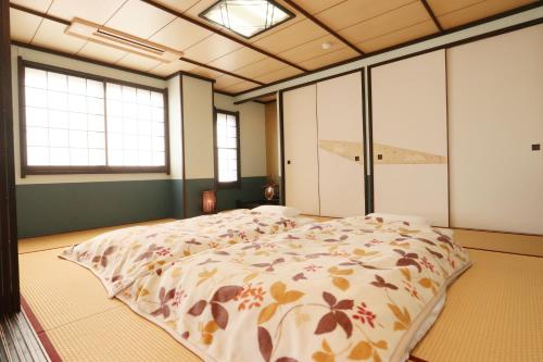 une chambre avec un lit dans une pièce avec des fenêtres dans l'établissement Umimoto, à Hakone