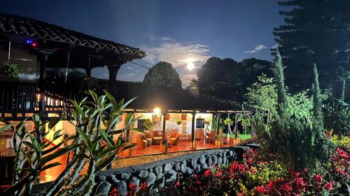 una casa con un patio con sillas y flores en Hotel Hacienda Anacaona - San Agustín, en San Agustín