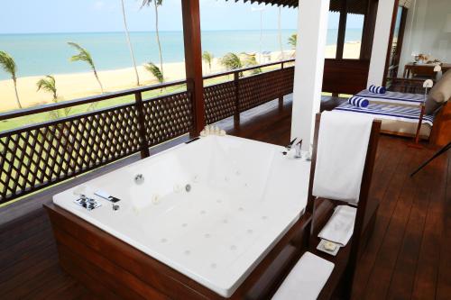 a bath tub in a room with a view of the beach at Anantaya Resort & Spa Chilaw in Chilaw