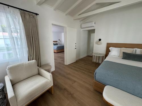 a bedroom with a bed and a chair and a window at Casa Palma Hotel & Bungalows in Palm Springs