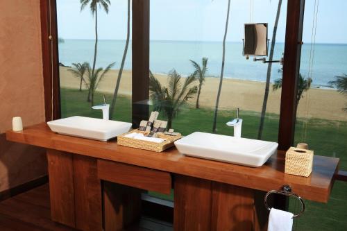 two sinks in a bathroom with a view of the beach at Anantaya Resort & Spa Chilaw in Chilaw