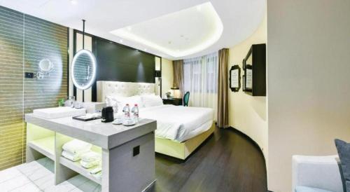 a hotel room with a bed and a bathroom at Xana Hotelle Wuxi Railway Station Zhongshan Road in Wuxi