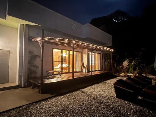 a house with lights on the side of it at night at アジアンウッドコテージ in Motobu