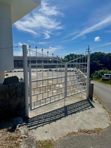 a gate on the side of a road with a train at アジアンウッドコテージ in Motobu