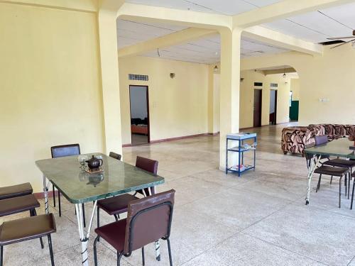a large room with tables and chairs and a couch at SINHARAJA GUEST INN Rakwana in Rakwana