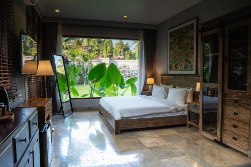 a bedroom with a bed and a large window at Seaside Oceana Suites by Mahaprana in Tejakula