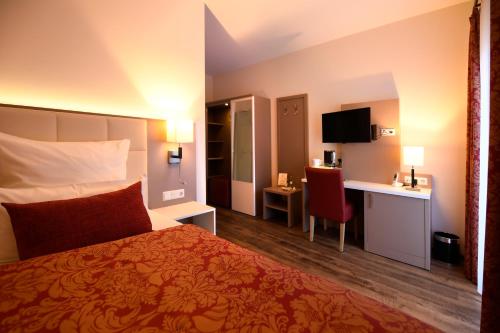 a hotel room with a bed and a desk at Hotel Marktkieker in Großburgwedel