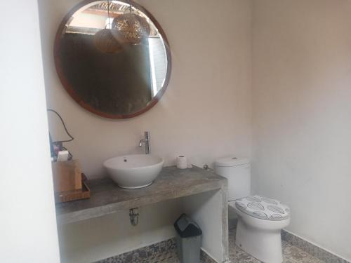 a bathroom with a sink and a mirror on the wall at THE OWN PENIDA COTTAGE & SPA in Nusa Penida