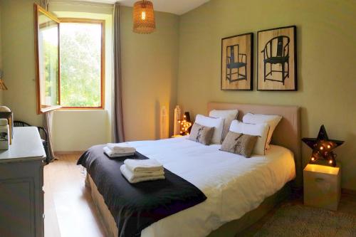 une chambre avec un grand lit blanc avec une fenêtre dans l'établissement Hameau Domaine Ceyrac, à Ceyrac