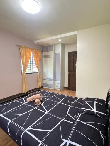 a bedroom with a black and white bed and a window at C7 Hotel with beach front access in Iloilo City