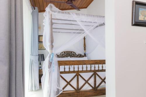 a room with a canopy bed in a house at Villa Sea Wave in Hikkaduwa