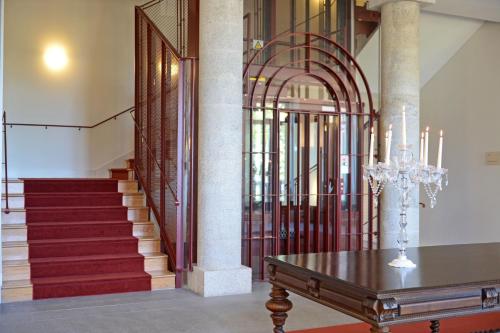 a room with stairs and a table with a chandelier at Pousada da Serra da Estrela in Covilhã