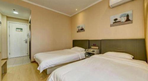 a hotel room with two beds and a phone at GreenTree Alliance Hotel Qinghuangdao Wanda Plaza in Qinhuangdao