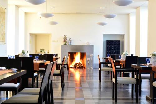 a restaurant with tables and chairs and a fireplace at Pousada da Serra da Estrela in Covilhã