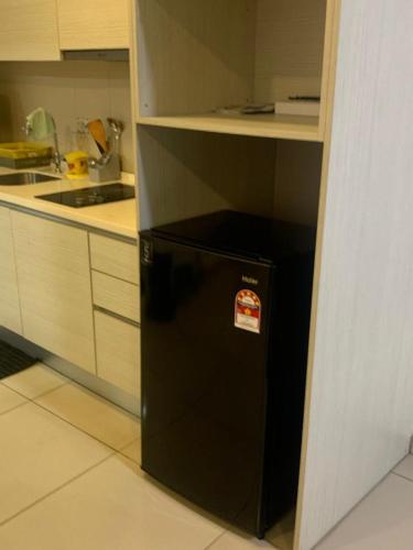 a black refrigerator with a sticker on it in a kitchen at cozy isoho shah alam in Shah Alam