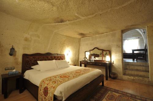 a bedroom with a large bed and a mirror at Dreams Cave Hotel in Ortahisar