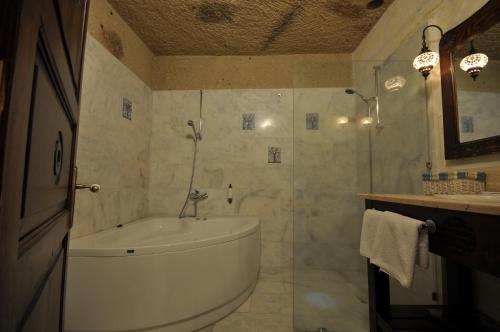 a bathroom with a tub and a sink at Dreams Cave Hotel in Ortahisar