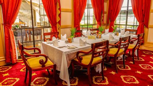 ナイロビにあるWindsor Golf Hotel & Country Clubの白いテーブルと椅子のあるダイニングルーム