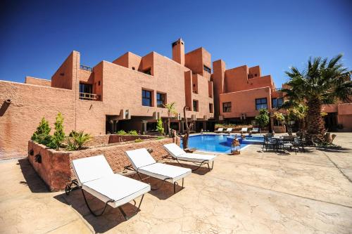 a resort with white chairs and a swimming pool at Hotel Xaluca Dades in Boumalne