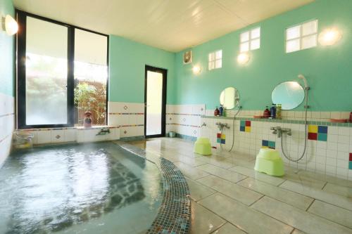 une grande salle de bains avec une piscine et une baignoire dans l'établissement Umimoto, à Hakone