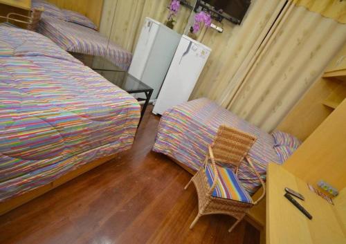 a bedroom with a bed and a chair and a table at Residencial Morumbi Hostel in Sao Paulo