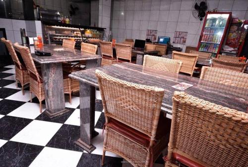 comedor con mesa y sillas de mimbre en Residencial Morumbi Hostel, en São Paulo