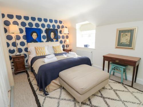 a bedroom with a bed with a blue and white wall at Fairview Cottage in Burford
