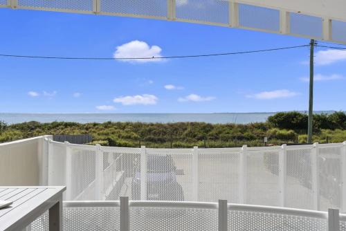 a balcony with a white fence and the ocean at Woorim Waves in Woorim