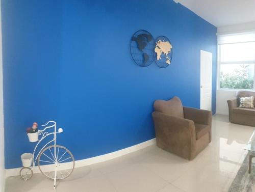 a room with a blue wall with a bike and a chair at HARLOE'S SUITe in Kingston
