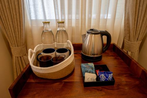 a wooden table with two glass bottles and a tea kettle at C Roque Beach Resort in Colva