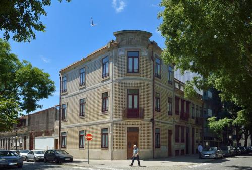 a woman walks past an old building on a street at Dukes Corner Guest House in Porto