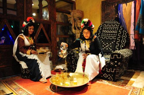 two women are sitting in a room with a table at Hotel Xaluca Dades in Boumalne