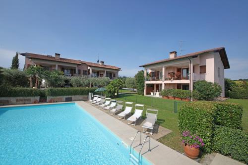 a villa with a swimming pool in front of a house at Corte degli Olivi Appartamenti in Manerba del Garda